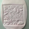 Baby shower-themed fondant cookie stamped with balloons and gifts using acrylic embosser stamp