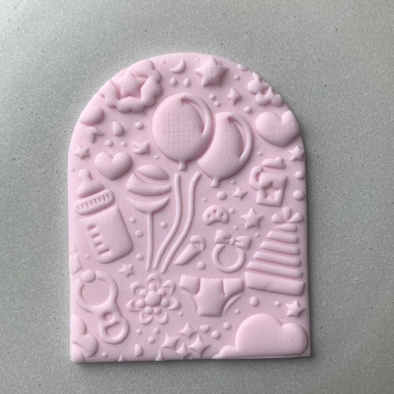 Fondant cookie embossed with baby bottle and presents using baby shower cookie stamp