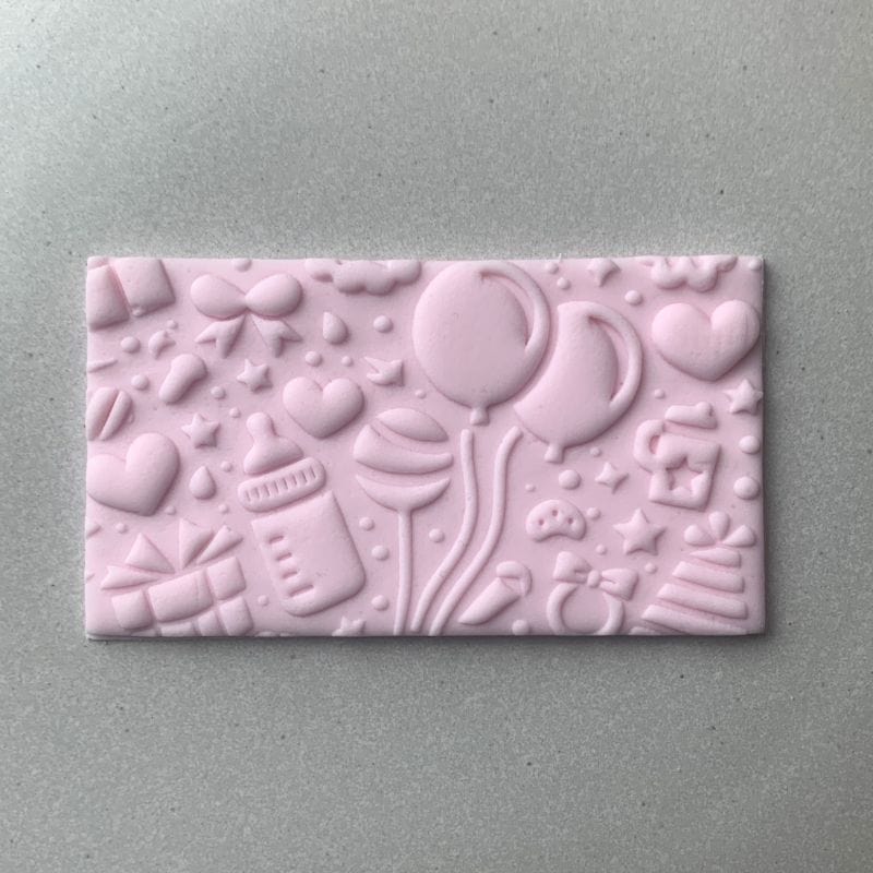 Baby shower cookie design in fondant, embossed with balloons and gifts using a rectangular cookie stamp