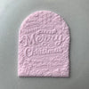 Arched fondant cookie embossed with Merry Christmas design using a festive cookie stamp